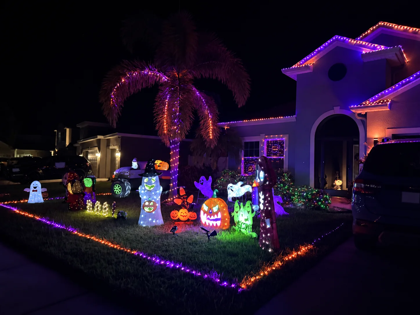 Completed Halloween display with purple and orange roofline lighting